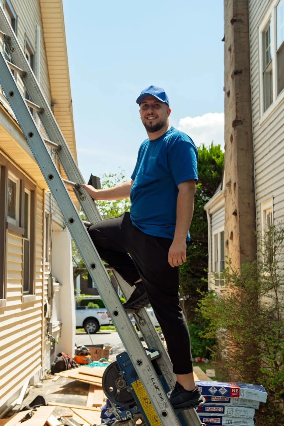 Crew member climbing a ladder to check roof damage